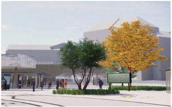 Förslag på eventuell placering av Ruth Ewans vinnande förslag "Everything Must Change". Bild: Petter Yxell. Klafftavlan står utanför stationen mellan några träd. Runtomkring rör sig människor.