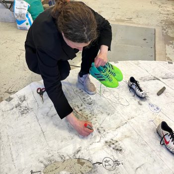 Konstnären Linnéa Jonsson arbetar med skoavtrycken som i ett senare skede hamnade i verkets betongfundament.